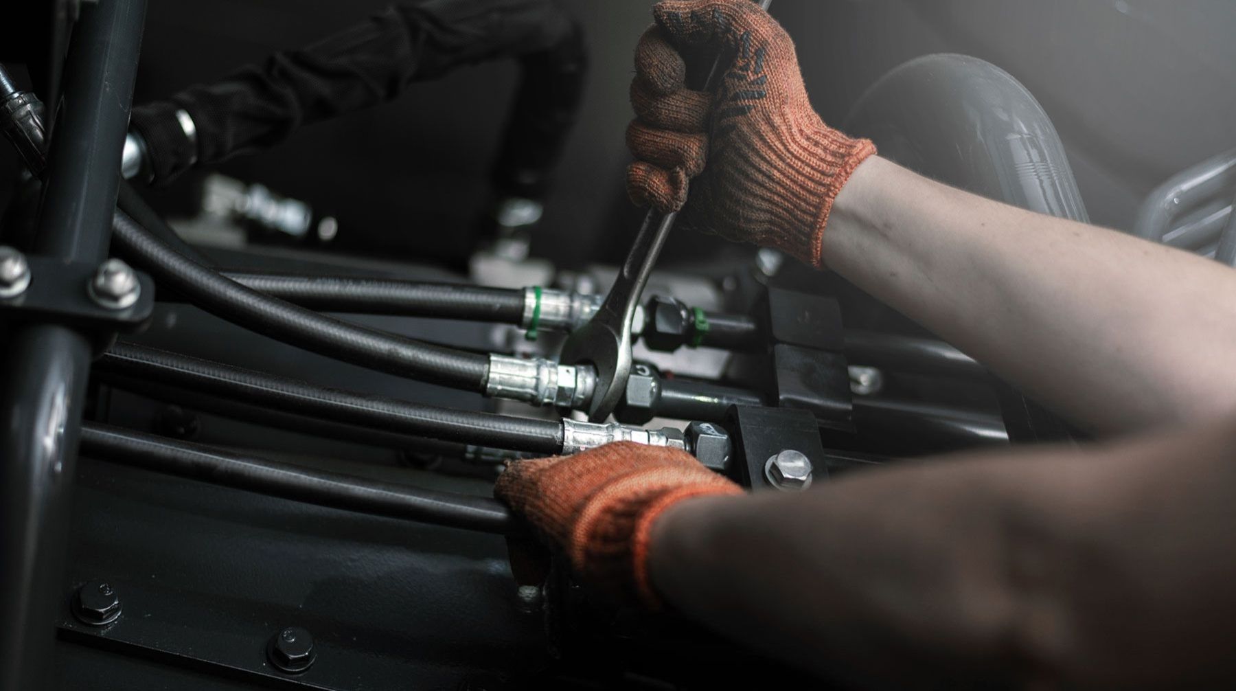 Nahaufnahme der Hydraulikrohre einer Schwerindustriemaschine, welche repariert werden.